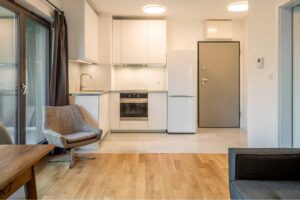 Room with wood floors, open kitchen, and sliding doors