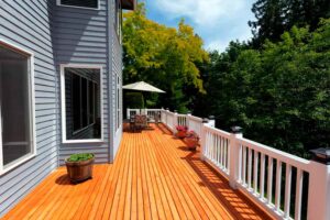 Lounge area with umbrella on a stained deck.