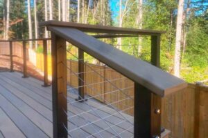 Stairs leading up to deck overlooking forested area.